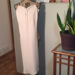 Cream colored, below the knee polyester dress.